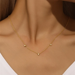 Close-up of gold S925 sterling silver necklace with three star pendants on model neck