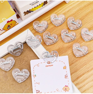 Macro shot of mini heart-shaped transparent plastic clips on a wooden desk