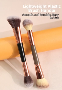 Close-up of dual-ended makeup brushes with rose gold metal ferrules and soft synthetic bristles