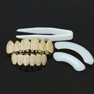 Close-up of gold hiphop grillz set with micro-paved zircons and fixing accessories