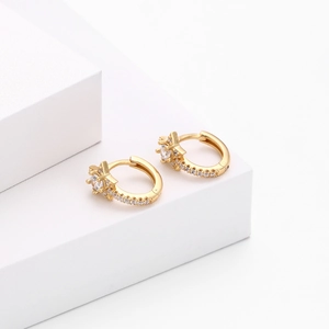 Detail of gold S925 sterling silver star huggie earrings with white cubic zirconia stones