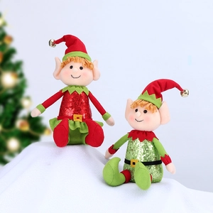 Detailed view of two Christmas elf plush dolls with sequins and golden bells on a snowy surface
