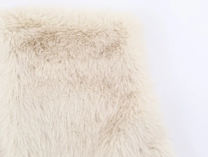 Close-up of fluffy beige faux fur texture with high density soft fibers and plush detail