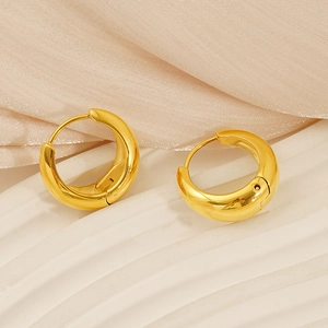 Close-up of chunky gold hoop earrings with polished finish on a luxury silk background