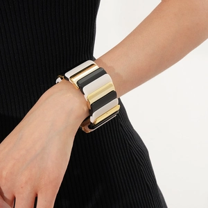 Detail of wide geometric stretch bracelet with black white and gold resin blocks