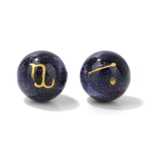 Macro detail of 10mm blue goldstone beads with celestial zodiac gold engravings