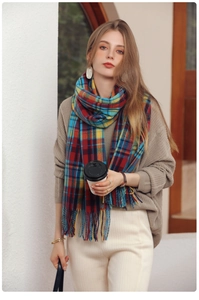 Detailed view of colorful plaid pattern and soft tassel texture on a winter scarf