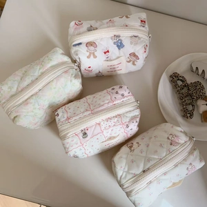 Detail of four quilted cotton makeup bags with cute cartoon bears and floral patterns