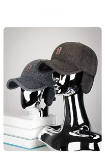 Detail view of winter baseball cap with ear flaps and leather logo patch for men