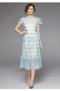 Détail de broderie florale sur robe à volants en tulle bleu clair avec bords en dentelle
