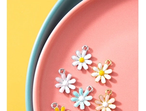 Close-up of colorful daisy charms in white, pink and blue for DIY jewelry making