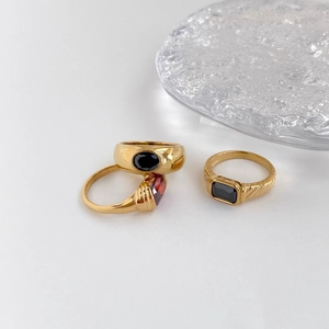 Three-piece vintage gold-plated rings set with black oval and red-brown gemstones