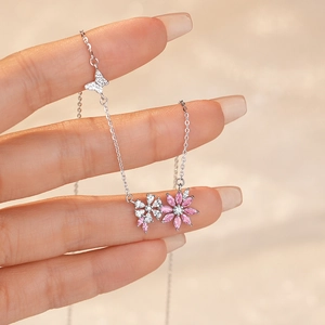 S925 sterling silver necklace with pink zircon flower and butterfly pendant held by hand