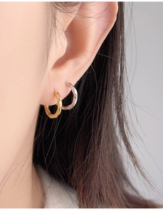 Side view of Mobius loop earrings in gold and silver showing irregular pleated texture
