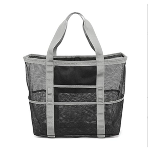 Macro view of black mesh beach bag with gray handles and multiple side storage pockets