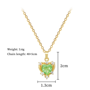 Macro shot of green heart zircon necklace with gold chain and clear crystal details