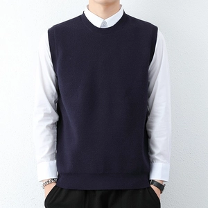 Men's navy knit vest with round neck paired with white shirt for a clean layered look