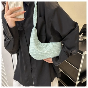 Detailed view of mint green bubble texture on a soft pleated underarm shoulder bag