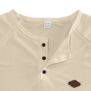 Close-up of waffle knit texture and buttoned placket on beige men's long sleeve Henry shirt