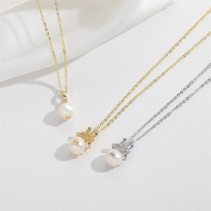 Elegant vintage crown pearl pendant necklaces in gold and silver on white silk
