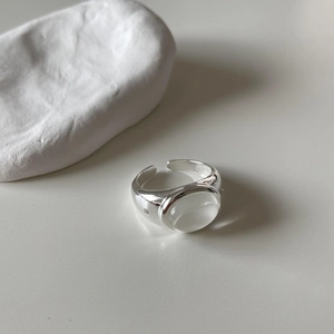 Detail of adjustable S925 silver ring with oval moonstone on a minimalist background