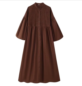 Detail of dark brown pleated maxi dress with vertical folds and buttons on the chest