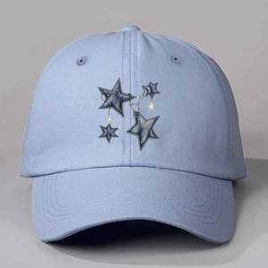 Detail of light blue cotton cap with dark blue star patches and fine metal chain pendant