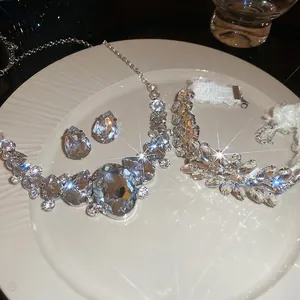 Luxury silver-tone jewelry set featuring teardrop crystals on a textured white plate
