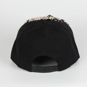 Detail view of black punk baseball cap with decorative metal studs and snapback closure