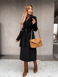 Chic long black wool coat styled with tall brown boots and a premium leather handbag