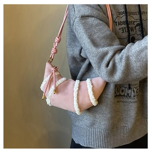 Dettaglio della borsa croissant rosa in pelle scamosciata con strisce di shearling