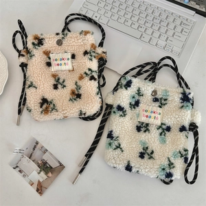 Close-up of fuzzy plush crossbody bags with vibrant rainbow dot patterns and metal snaps