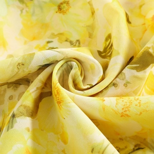Nahaufnahme des lebhaften gelben Blumenmusters mit elegantem Faltenwurf und Textur