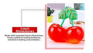 Detailed macro view of rhinestone cherry keychain with green leaves and golden ring