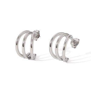 Macro view of silver triple-layered C-shaped earrings with polished metallic finish