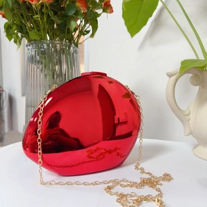 Polished red mirror egg-shaped evening bag with a gold metal chain strap detail