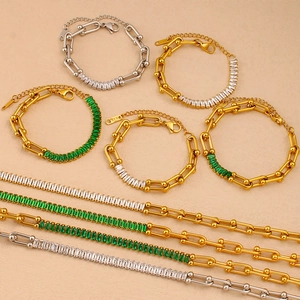 Detailed flat lay of 18K gold and silver U-link chains with zircon gemstone accents