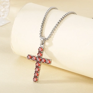 Detail of red rhinestone cross pendant with silver box chain on jewelry display stand
