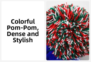 Macro view of a dense red, green and white pom-pom on top of a winter knitted hat