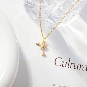 Detailed view of a gold 'Y' letter pendant with clover zircon on a minimalist chain