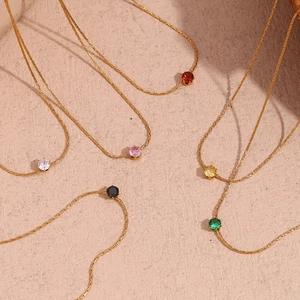 Close-up of gold plated chains with multi-colored mini zircon stones in various colors