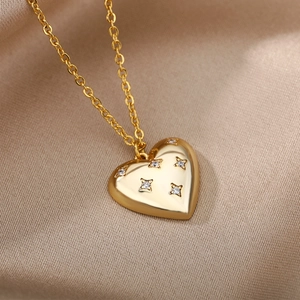 Close-up of golden heart pendant necklace with star-patterned crystals on satin