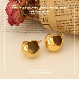 Detail of 18k gold plated surgical titanium steel U-shaped earrings on retro background