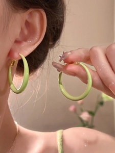 Detail of light green enamel hoop earring on model showing high quality glossy finish