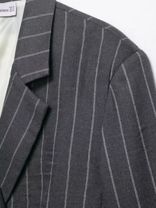 Close-up of the shoulder and lapel detail on a dark grey pinstripe women's suit blazer