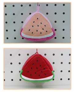 Close-up of plush watermelon coin purses in pink and red with detailed seed embroidery