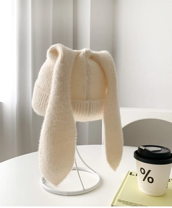 Close-up of soft beige knit rabbit ear hat showing fluffy texture and warm wool fabric