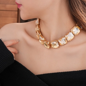 Dettaglio della collana dorata con grandi cristalli rettangolari color champagne