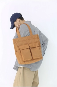 Side view of a vintage khaki canvas tote bag with large cargo pockets for travel