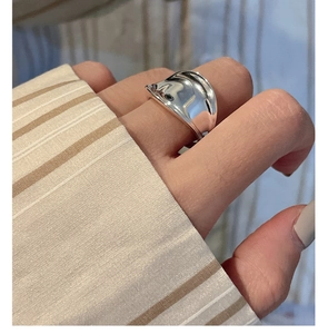 Close-up of minimalist S925 sterling silver saddle ring with irregular wavy texture